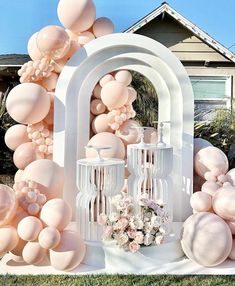 an outdoor wedding setup with balloons and flowers