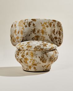 an upholstered chair with gold flowers on it's seat and back, against a white background