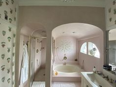 a bathroom with a tub, sink and mirror in it's center wall is shown