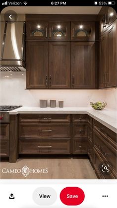 a kitchen with wooden cabinets and white counter tops is pictured in this image, there are lights on above the stove