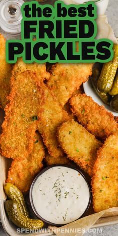 fried pickles in a basket with dipping sauce and pickle slices on the side