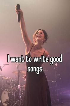 a woman in a black dress holding up a microphone and singing on stage with the words i want to write good songs