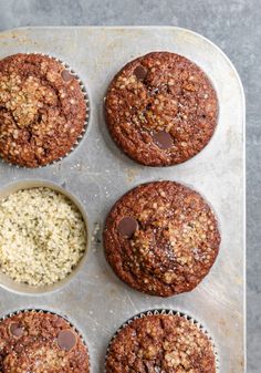 chocolate chip muffins in a muffin tin with two bowls of oatmeal