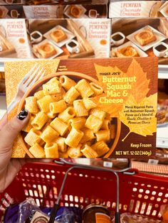 a person holding up a box of butternut squash placemats in a grocery store