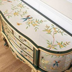 an ornately painted dresser with birds and flowers on the drawers is shown in this image