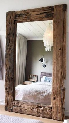 a bedroom with a large mirror on the wall above it and a bed in the background