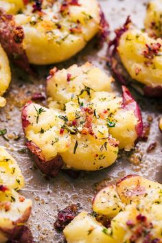 cooked potatoes with herbs and seasoning on a baking sheet, ready to be eaten