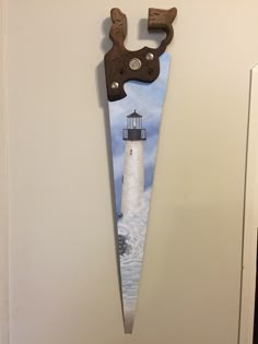 a door hanger with a painting of a lighthouse on it