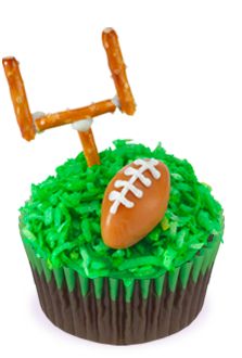 a cupcake decorated with green frosting and a football on top that has a pretzel sticking out of it