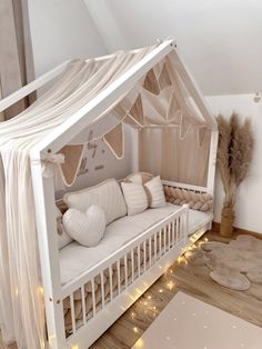 a white crib with pillows and lights on the floor