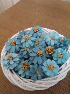 small blue flowers in a white basket on a table