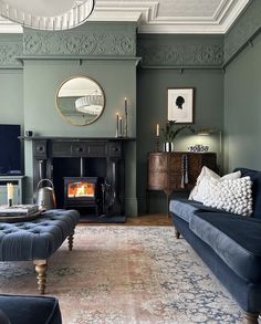 a living room filled with furniture and a fire place in the middle of the room