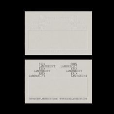 two white business cards sitting on top of each other in front of a black background