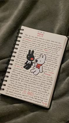 a notebook with an image of a dog and cat on it sitting on a bed