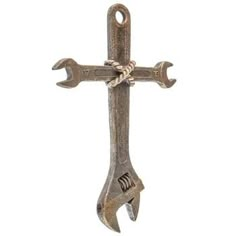 an old metal cross with two wrenches hanging from it's side on a white background