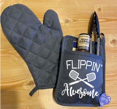 an oven mitt with two cooking utensils in it next to a pair of gloves