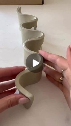 someone is making a vase out of clay with their fingers and thumb on the edge