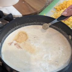 a person is stirring some food in a pot on the stove with a spatula