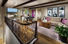 a living room filled with furniture and pictures on the wall next to a stair case