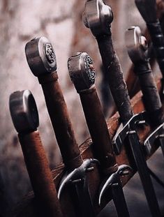 there are many different types of wrenches on the rack in front of a brick wall