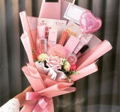 a woman holding a pink bouquet filled with lots of items