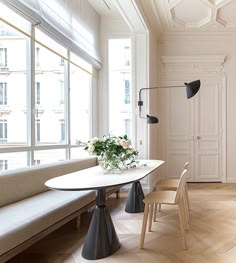 a living room filled with furniture next to a window covered in lots of windows and white walls