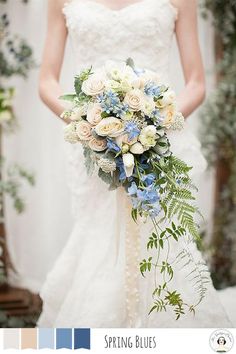 a bride holding a bouquet of white and blue flowers