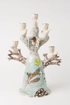 a ceramic figurine that is holding candles