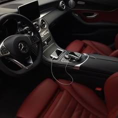 the interior of a car with red leather seats and steering wheel, including an mp3 player