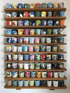 a shelf filled with lots of different kinds of coffee mugs on it's sides