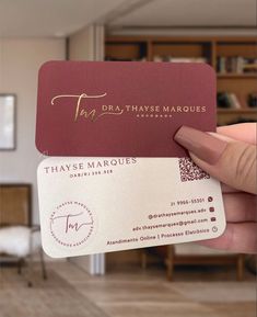 a person holding up two business cards in their hand, with the words that says thasse marques on them