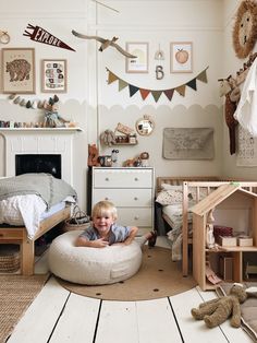 a little boy that is laying down on a bed in a room with some toys