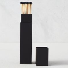 an open black box with matches in it next to a small square container filled with matches