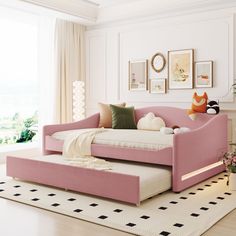 a living room with a pink couch and white rugs on the floor next to a window