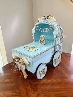 a blue cart with a teddy bear on the front and sides, sitting on top of a hard wood floor