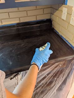 a woman in blue gloves is cleaning the floor