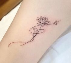 a small tattoo on the leg of a woman with a flower in her left arm