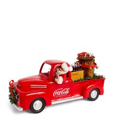 an old fashioned coca - cola truck with a santa clause on the back and christmas decorations in the bed