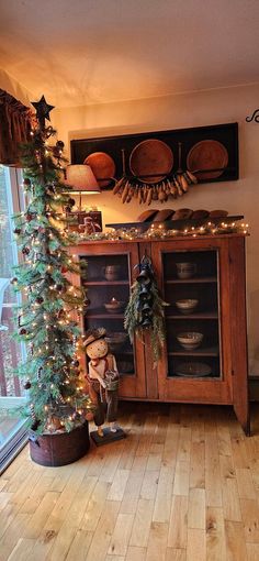 a small christmas tree is in the corner of a room with wooden floors and walls