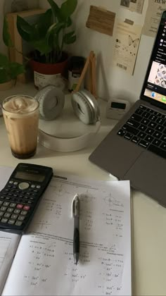 a laptop computer sitting on top of a desk next to a calculator