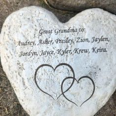 a heart - shaped stone with two hearts inscribed on it, in the shape of a couple's names