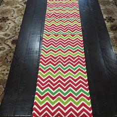 a long table runner with red, green and white chevrons on the edge