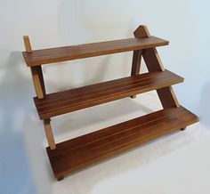 two wooden shelves sitting on top of each other in front of a white wall and floor