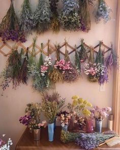 a bunch of flowers that are sitting on a table next to a wall mounted planter