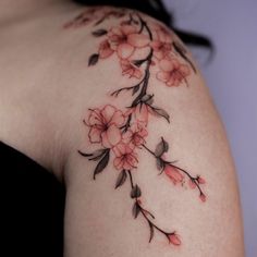 a woman's shoulder with pink flowers on the top and bottom part of her arm