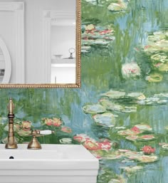 a bathroom sink sitting under a mirror next to a wallpaper covered in water lilies