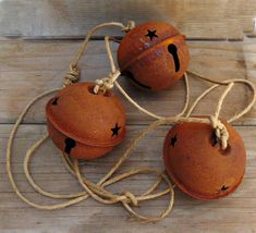 three orange balls with black stars on them tied up to string and sitting on a wooden surface