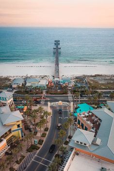 an aerial view of the beach and ocean with buildings on both sides, including a clock tower