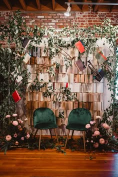 two green chairs sitting next to each other in front of a wall covered with books