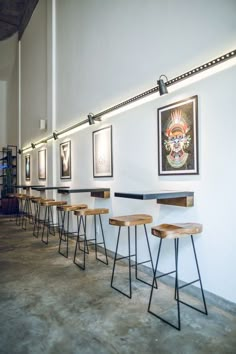 a row of bar stools sitting next to each other on top of a cement floor